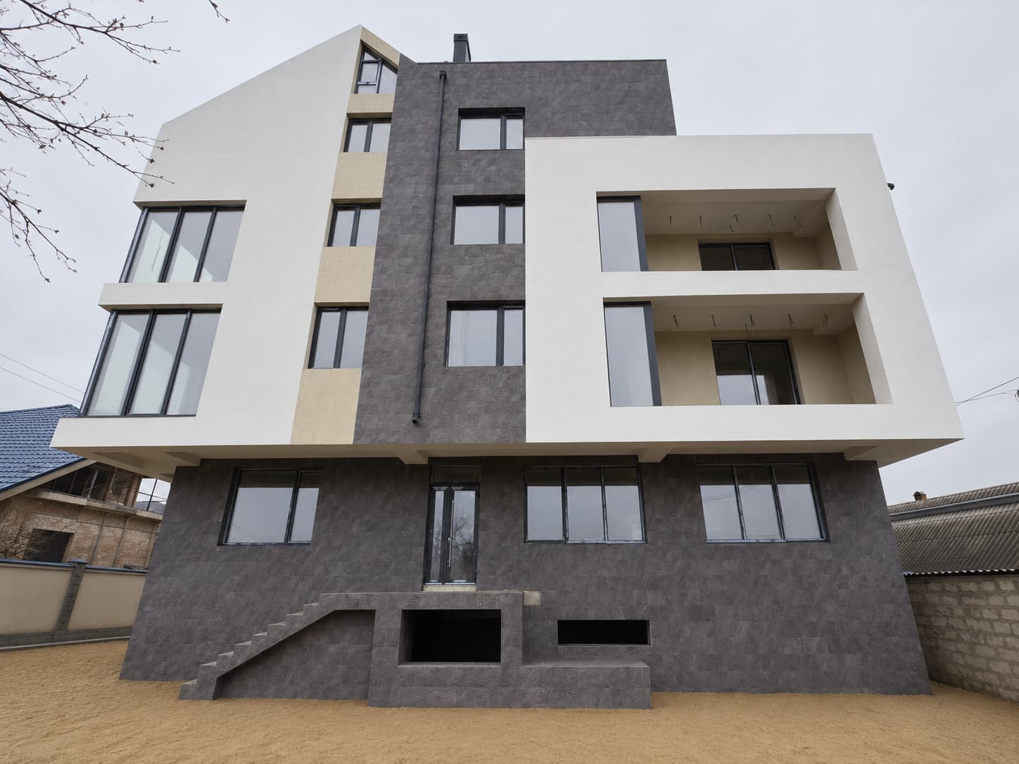 Main facade head-on: Royal Granite ground floor and vertical band between white volumes and beige inserts