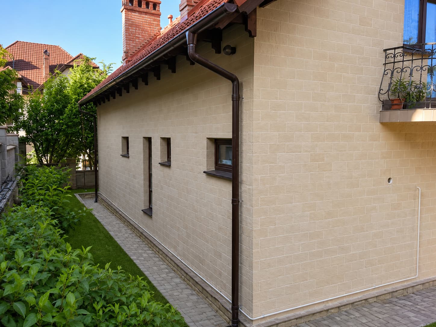 Side elevation clad in full, with small basement windows and returned reveals