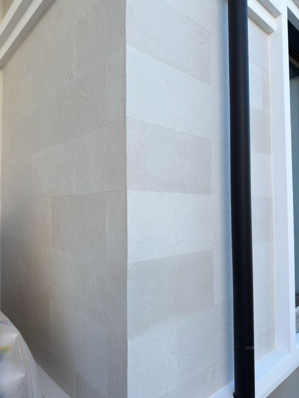 Corner column between a window and a wall, two faces of light flexible stone close up