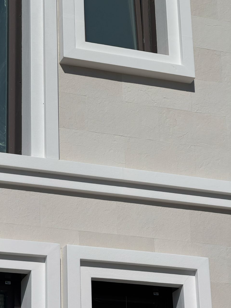 Field of flexible stone around a window with a white surround, close up