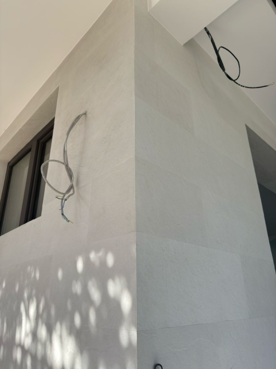 Corner edge with a window on the left and two faces of light flexible stone
